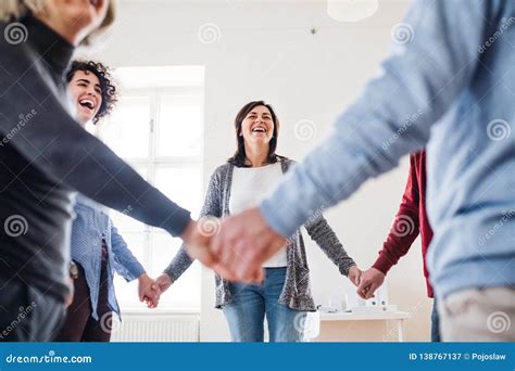 Midsection Of People Standing In A Circle And Holding Hands During