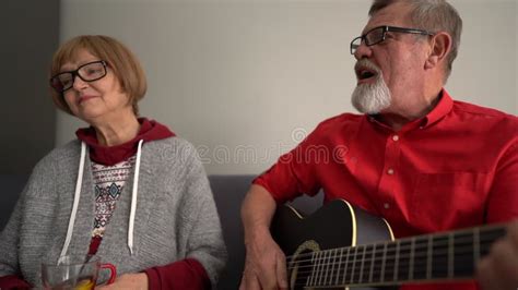 The Husband Plays The Guitar And The Wife Sings The Song Portrait Of An Elderly Couple Having A