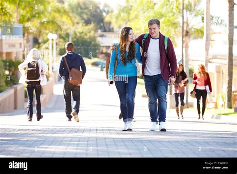 Student Couple Walking Outdoors On University Campus Stock Photo Alamy