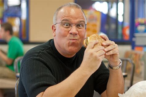 Man Eating Burger In Fast Food Restaurant Photograph By Gunter Nezhoda
