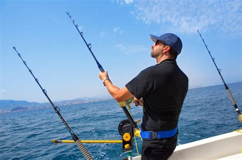Pescatore Di Mare Blu In Barca Da Pesca A Traina Con Downrigger Foto