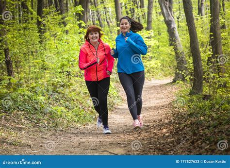 Madre E Hija Usando Ropa Deportiva Y Corriendo En El Bosque Imagen De