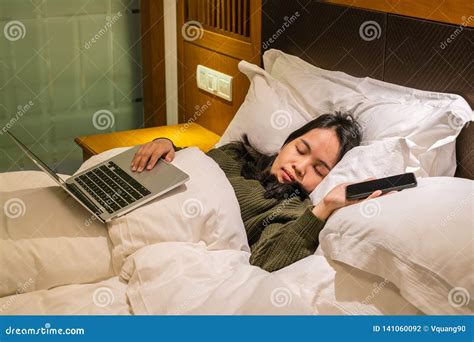 Young Asian Woman Sleeping On Bed After Working On Laptop In The