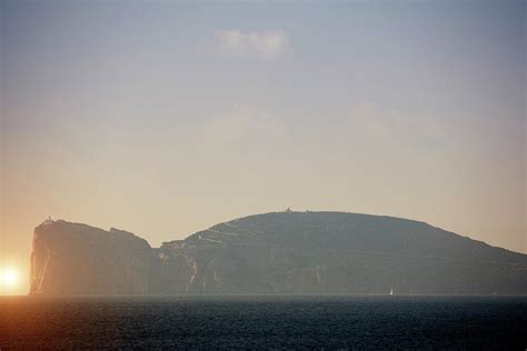 hazy coastal view with cliff top lighthouse capo caccia sardinia italy digital art by walter