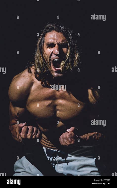 Shirtless Man Screaming While Standing In Darkroom At Gym Stock Photo Alamy