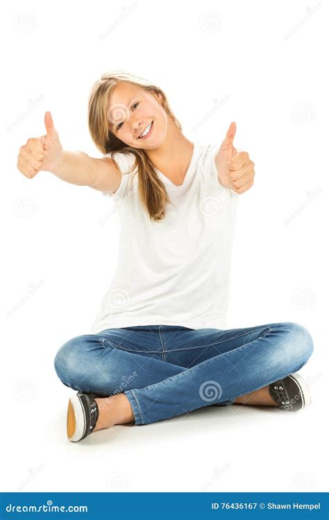 Young Girl Sitting On The Floor With Thumbs Up Over White Backgr Stock