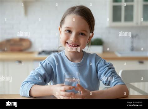 Headshot Portrait Little Girl Holding Glass Of Still Water Stock Photo