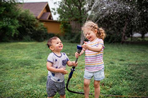 Two Children Playing With Garden Hose Stock Photo Offset