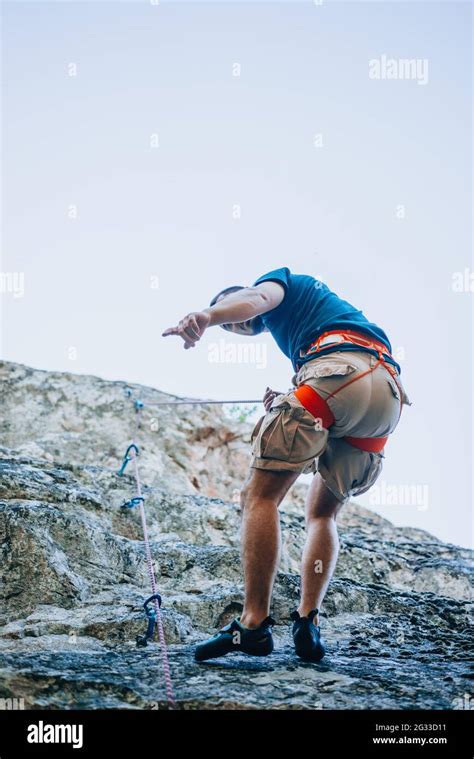 A Rockclimber Finding A Foothold On The Steep Mountain Hes Climbing