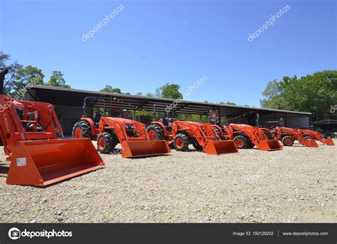 Images Kubota Tractors Line Of Orange Kubota Tractors Stock