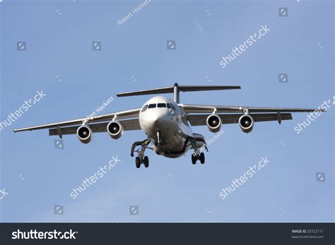 Small Four Engine Jet Aircraft On Final Approach To Land Stock Photo