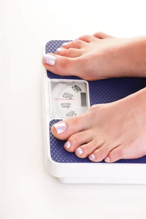 Woman Feet And Weight Scale Isolated On White Background Stock Photo
