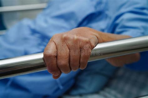 Asian Elder Senior Woman Patient Holding Bed Rail While Lie Down With