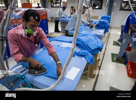 A Man Irons A T Shirt In A Garment Factory Where Organic Cotton Is