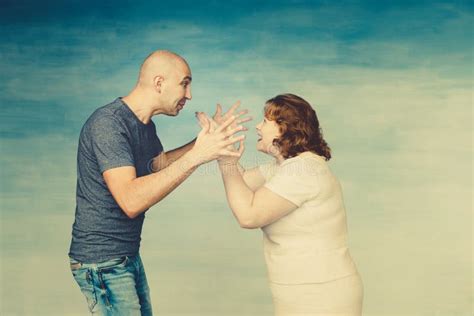 A Tall Bald Man And Plump Red Haired Attractive Woman On A Blue Background The Husband Scolds
