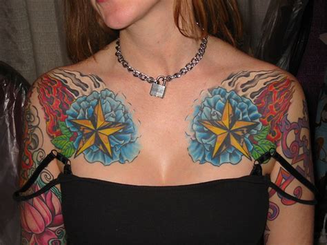 The tattoo artist has drawn the wings with red ink, the face and front area of the bird includes blue and green ink, and the end swirls consist of purple ink. Beautiful Chest Piece Tattoo Designs For Girls | YusraBlog.com