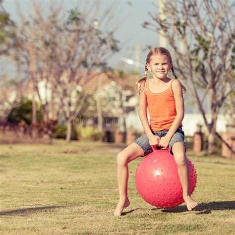 Happy Girl Playing With Inflatable Balls On The Lawn Stock Photo
