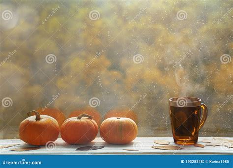 Autumn Background With Three Pumpkins Dry Leaves And Cup With Hot Tea
