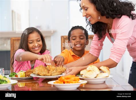 Mother Serving A Meal To Her Children At Home Stock Photo Alamy