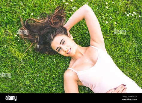 Pretty Brunette Woman Lying On A Lawn Stock Photo Alamy