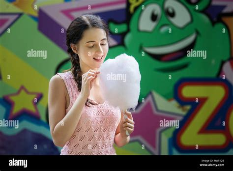Cute Caucasian Girl In Amusement Park Is Eating Pink Candyfloss