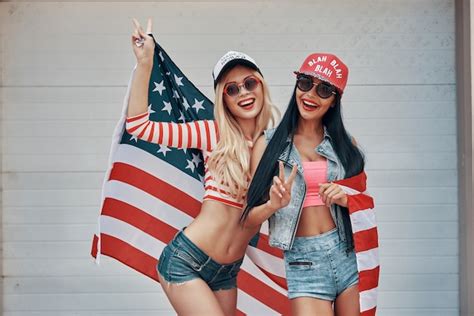 chicas americanas dos mujeres jóvenes juguetonas gesticulando el signo de la paz y sosteniendo