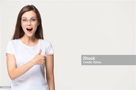 Opgewonden Tiener Meisje Wijzend Vinger Op Copyspace Geïsoleerd Op De Achtergrond Stockfoto En