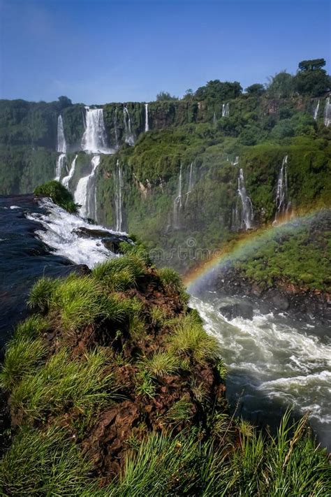 Water Cascading Over The Iguacu Falls In Brazil With Rainbow Stock