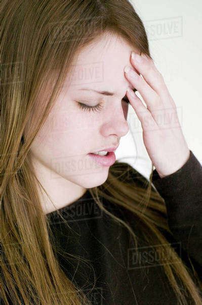 Young Woman Touching Forehead With Eyes Closed Stock Photo Dissolve