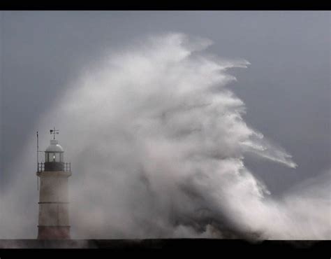 Waves Crash Against The Lighthouse And Sea Wall During High Winds And