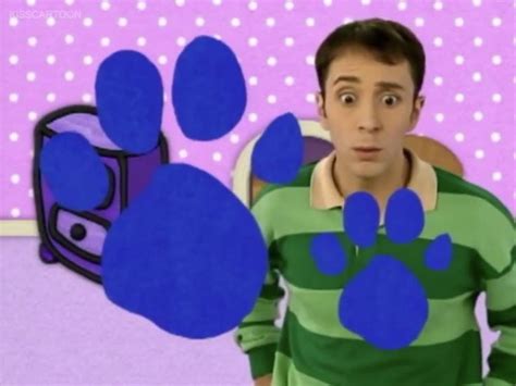A Man Is Standing In Front Of A Blue Paw Print