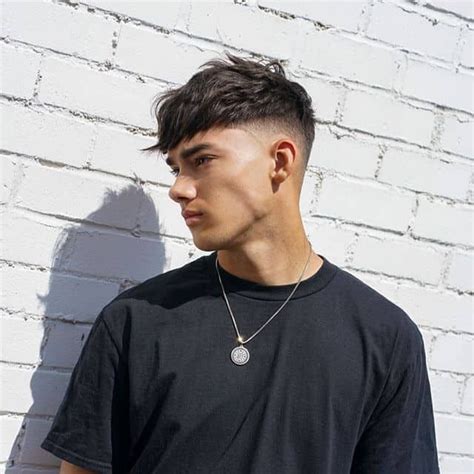 A Mid Haircut With Forward Swept Fringe And Medium Faded Sides And Back