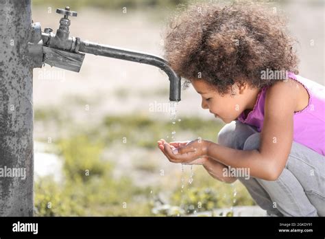 African American Child Drinking Water From Tap Outdoors Water Scarcity