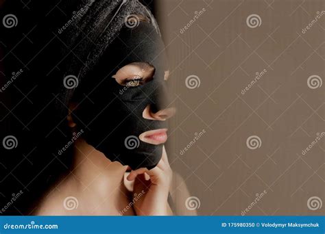 beautiful woman applying black facial mask beauty treatments close up portrait of spa girl