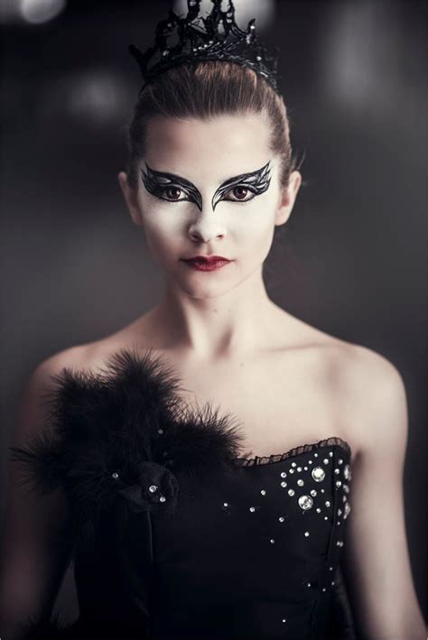 A Woman With Black And White Makeup Wearing A Tiara Feathered Headpiece