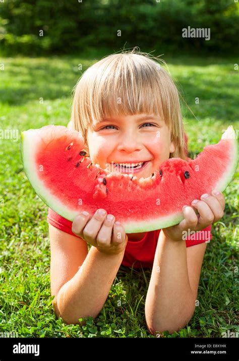 Happy Little Girl Eating Watermelon In A Garden Stock Photo Alamy