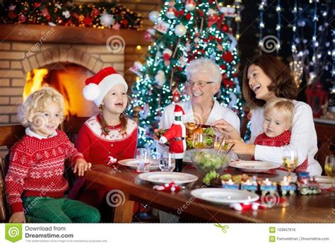 Kids sitting at christmas table with father. Christmas Dinner. Family With Kids At Xmas Tree. Stock ...