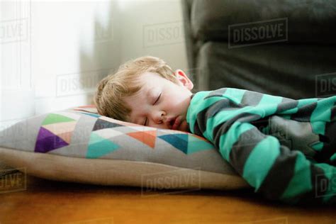 Tired Boy Sleeping On Floor At Home Stock Photo Dissolve