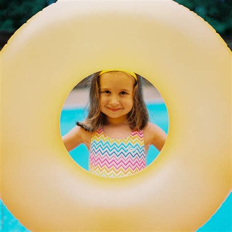 Cute Young Girl With A Big Inter Tube Standing By A Swimming Pool By