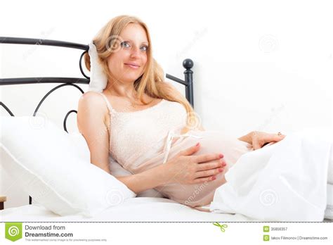 Blonde Cute Pregnant Woman On White Pillow In Bed Stock