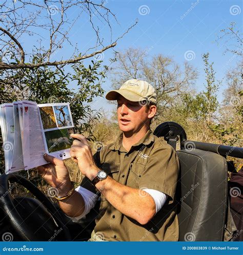 Safari Guide Ranger Instructing Guests About Animals In A Wildlife