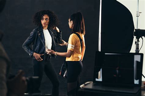 Stylist Adjusting Model During A Fashion Shoot Stock Photo Download