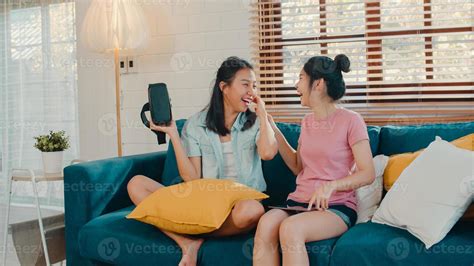 jóvenes lesbianas lgbtq mujeres asiáticas pareja usando tableta en casa amante asiática mujer