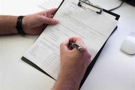 Person Filling Out Form Or Survey At Office Desk Stock Photo Image Of