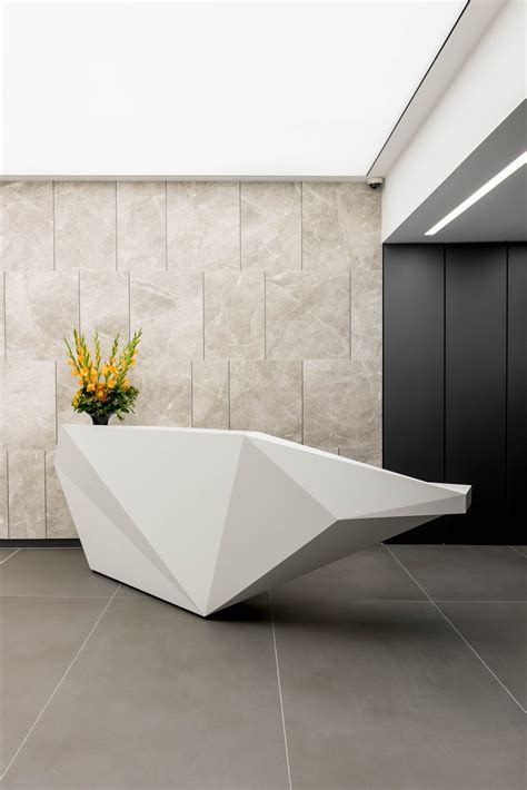 Bespoke faceted reception desk produced in solid surface for 10 Brook