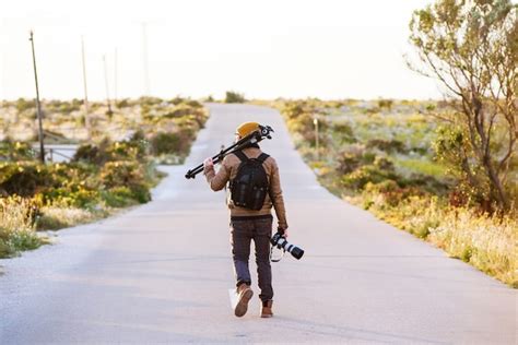 Joven Fotógrafo Caminando Por La Carretera Del Desierto Con Trípode En