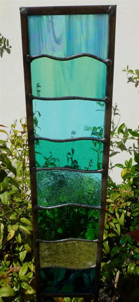 A Tall Stained Glass Window Sitting In The Grass