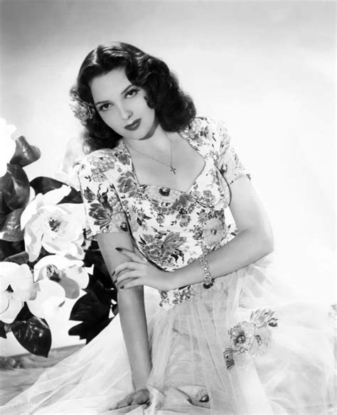 A Black And White Photo Of A Woman In A Dress With Flowers On Her Chest