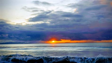 red sunrise on beach breaking waves | Iguana Lodge