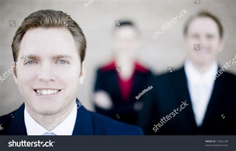 Close View Of Handsome Businessman With Businesspeople Standing In